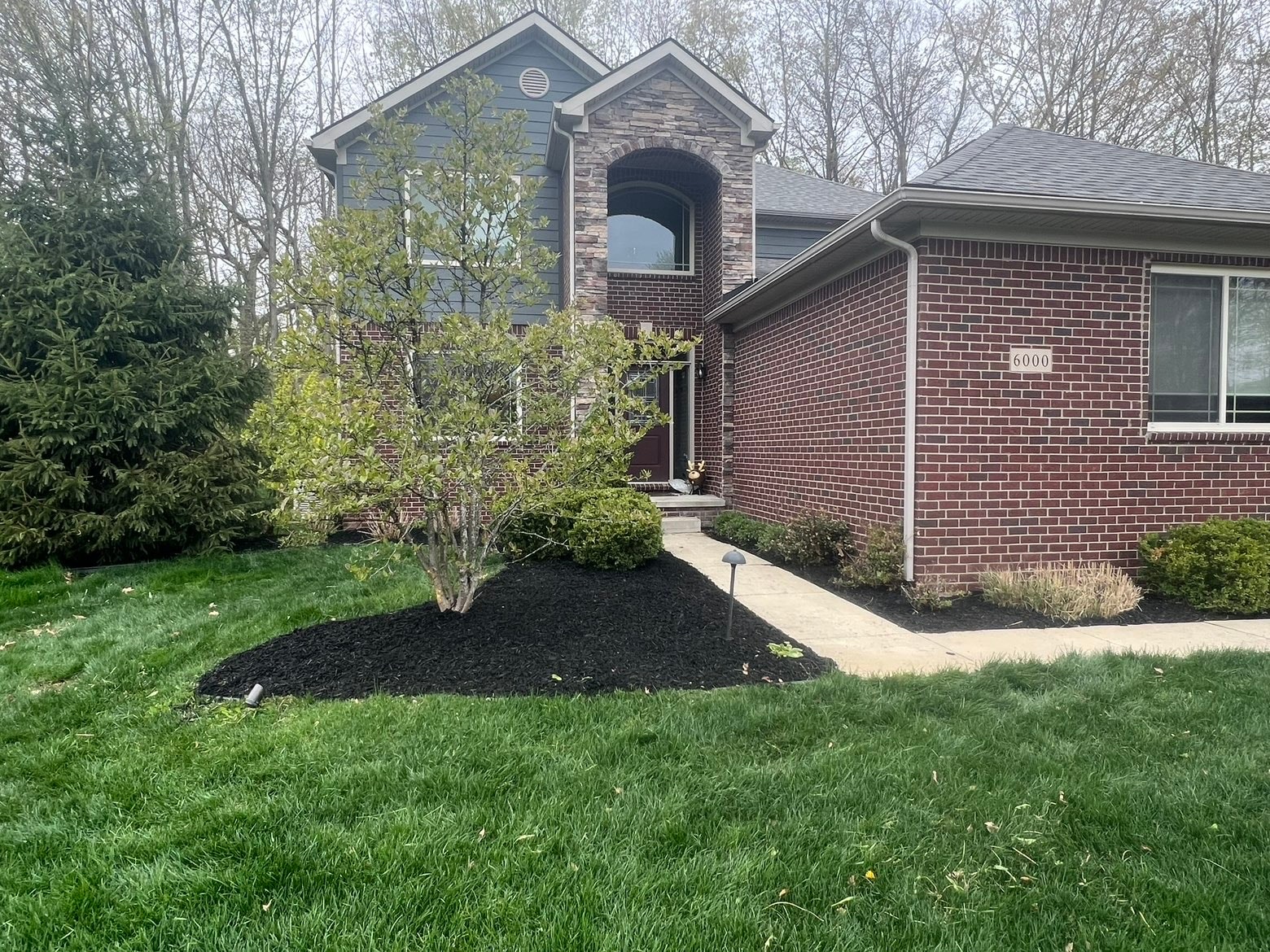 Brick house with manicured front yard — Bemis Landscaping