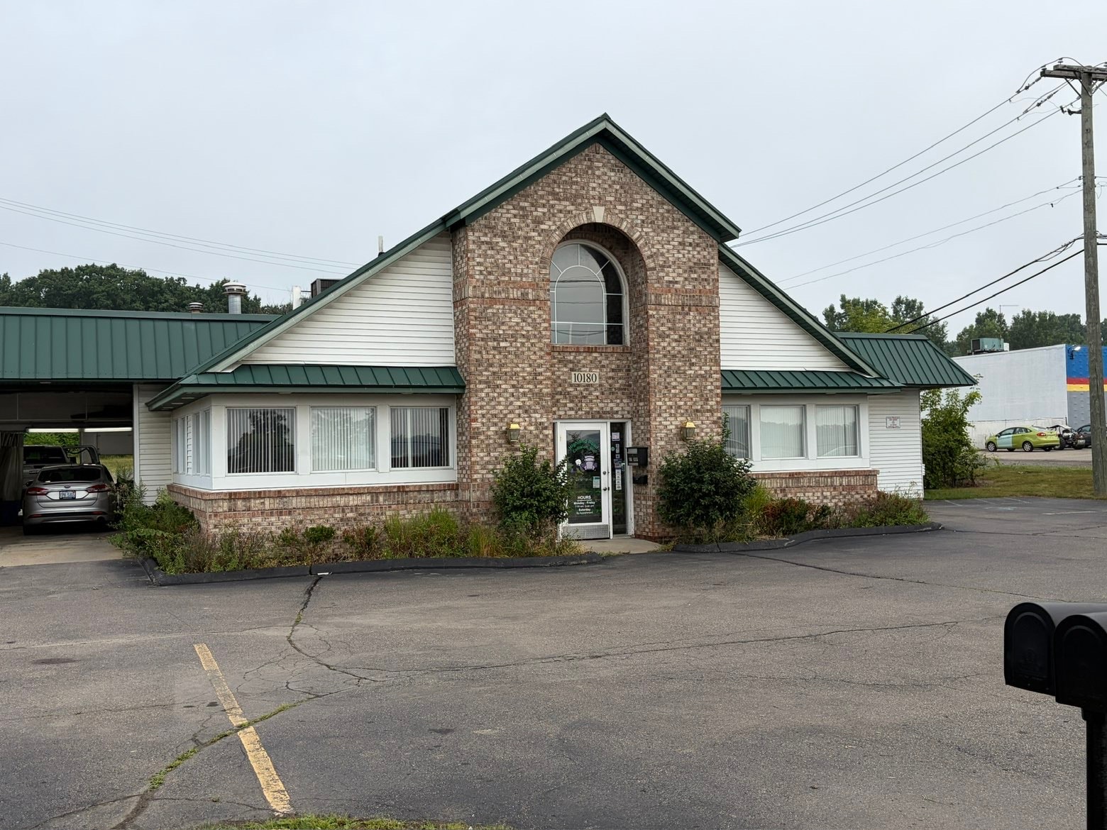 Brick house with manicured hedges — Bemis Landscaping